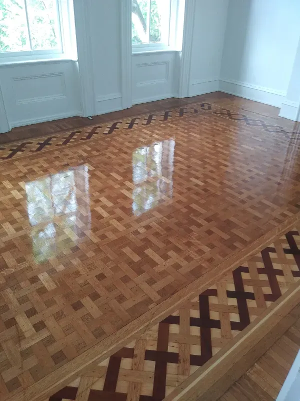 A wooden floor with a pattern on it in a room.