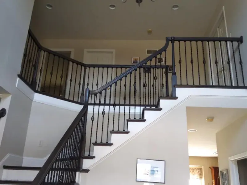 A staircase in a house with a black railing
