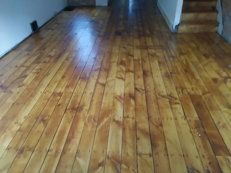 A wooden floor with a staircase in the background
