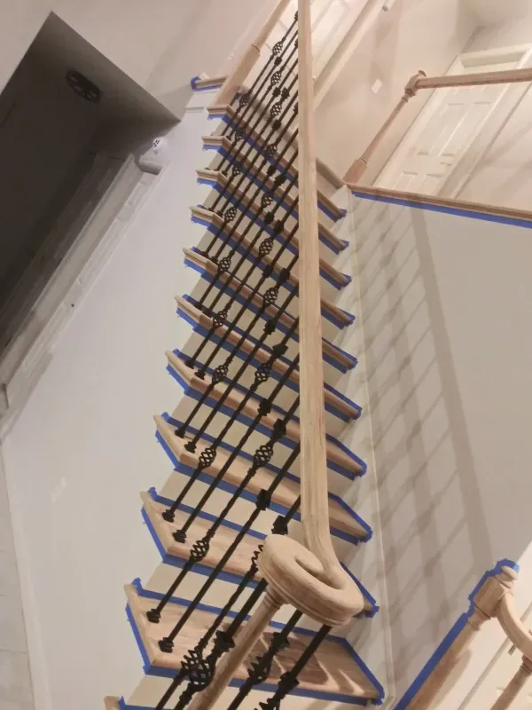 A staircase with blue tape on the steps and railing